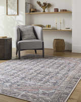 Living room scene with a gray chair on the beige, black, and blue Ameera Washable Area Rug. Roomscene-Rectangle