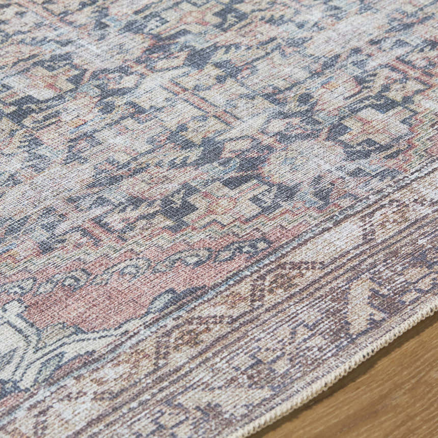 Close-up of the Ameera Washable Area Rug showing beige, black, and red traditional pattern and machine woven texture. Texture