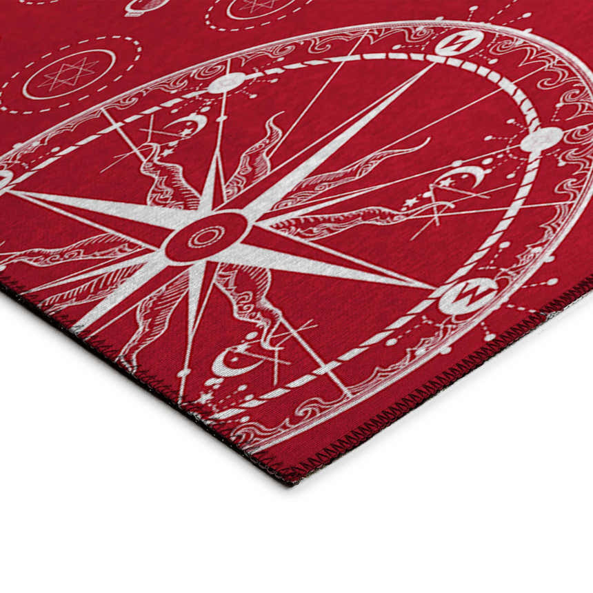 Close-up of the Dalyn Harbor HA9 Red Washable Area Rug featuring a white compass design and coastal pattern.