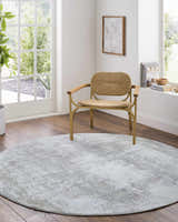 Light, airy room with a round Hanne Thick Luxe Rug in gray tones and a woven chair. Roomscene-Round