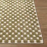 Close-up of the Anthea Olive Washable Area Rug. Olive and white checkerboard pattern, machine woven texture on wood floor. Front