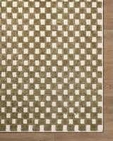 Close-up of the Anthea Olive Washable Area Rug. Olive and white checkerboard pattern with textured weave on wood floor. Corner
