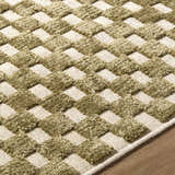 Close-up of the Anthea Olive Washable Area Rug. Olive and white woven diamond pattern with a soft, textured pile. Texture
