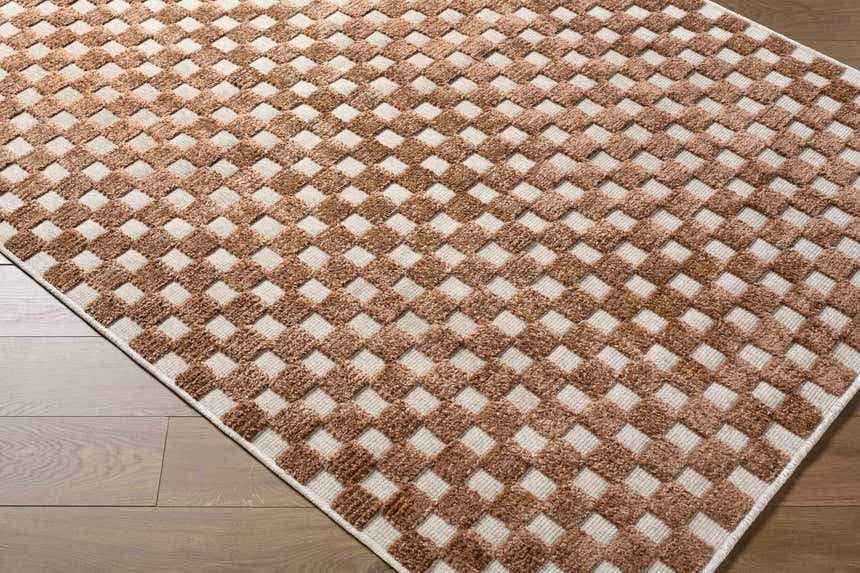 Close-up of the Anthea White Washable Area Rug. Brown textured squares on a white background create a contemporary geometric pattern. Corner