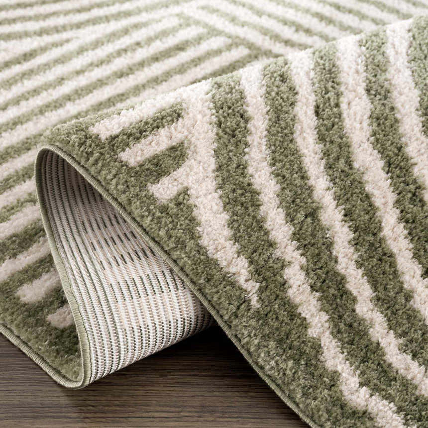 Close-up of the Allard Green Washable Area Rug showing its lime green and cream geometric pattern and soft, textured pile. Fold