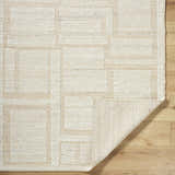 Close-up of the hand woven Alayka Area Rug. Beige wool rug with a contemporary geometric pattern. Fold