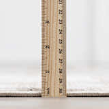 Close-up of the Galey Alix x Livabliss Myrtle Avenue I rug pile height in cream and taupe, measured with a ruler. Pile