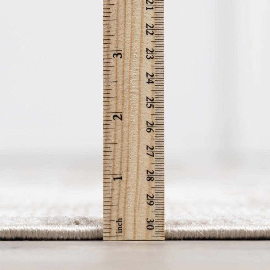 Close-up of the Galey Alix x Livabliss Myrtle Avenue I rug pile height in cream and taupe, measured with a ruler. Pile