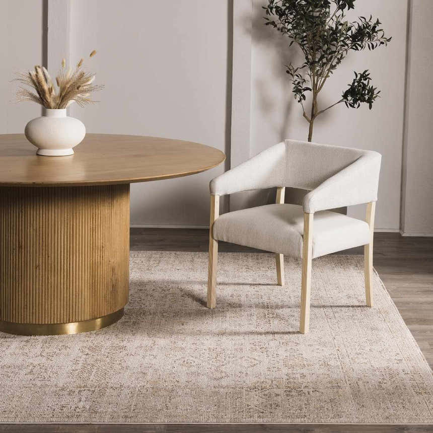 Dining room scene with a Galey Alix x Livabliss Myrtle Avenue I Area Rug in cream and taupe under a round wood table. Roomscene-Rectangle