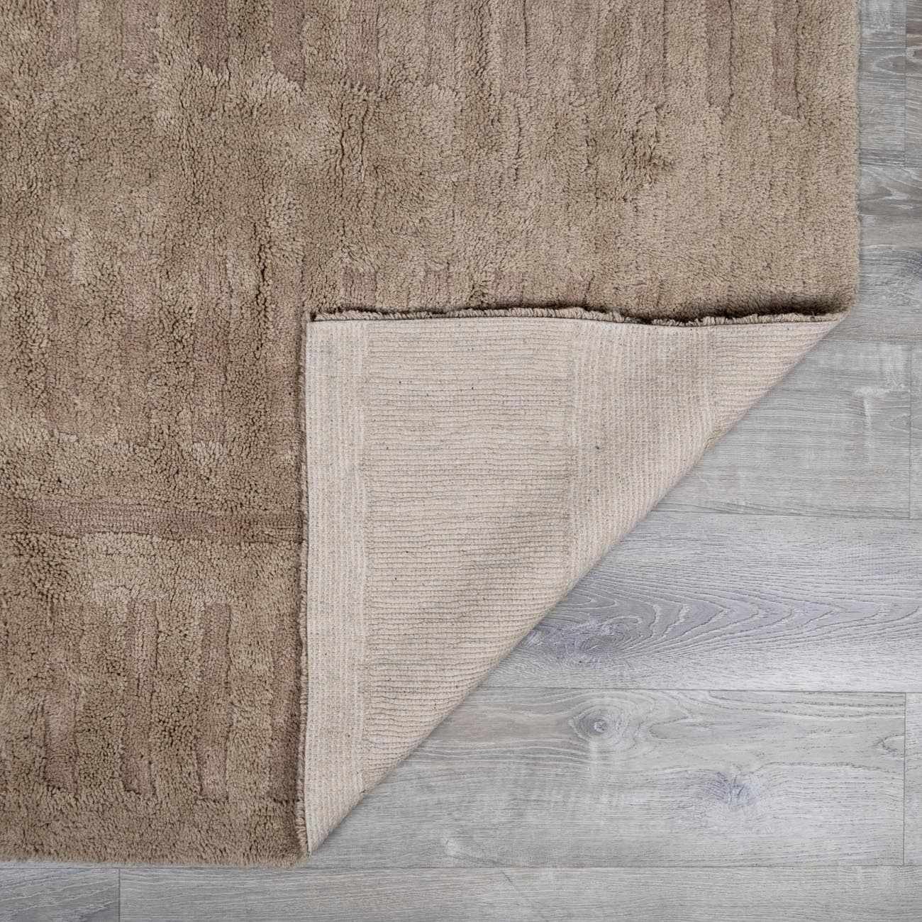Folded section of Washable Handmade Wool Rug - Brown, displaying material thickness and weave. Contemporary, Broken Striped, Textured Area Rug Backing  