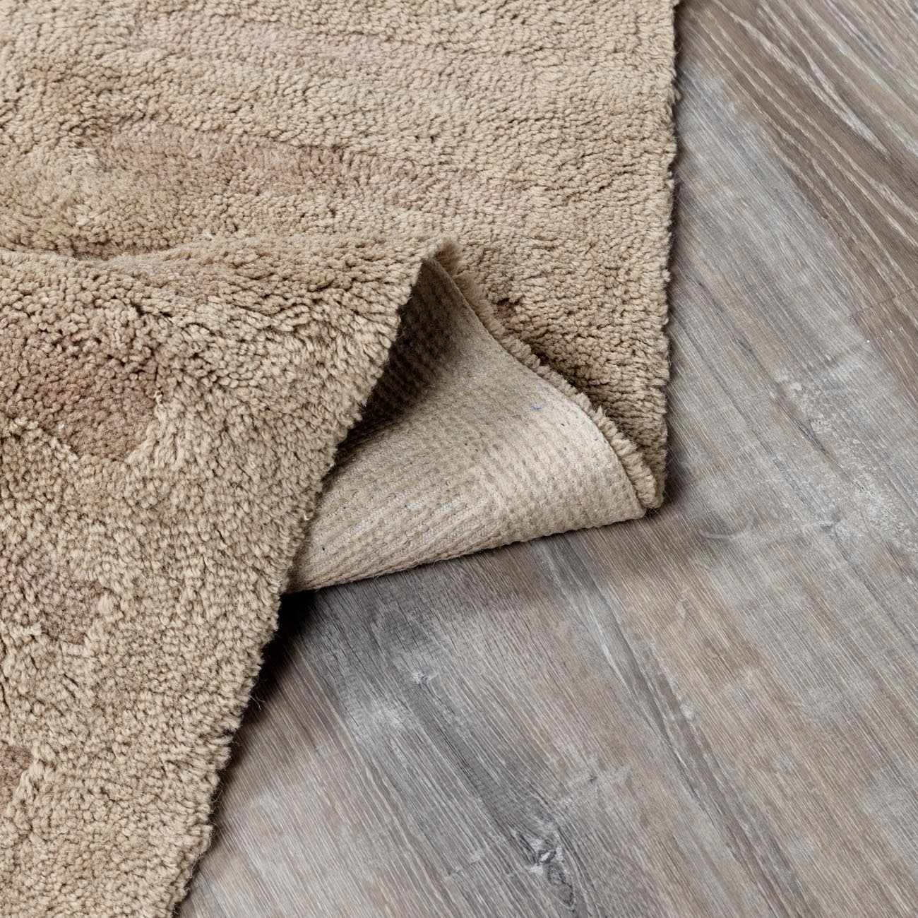 Folded section of Washable Handmade Wool Rug - Brown, displaying material thickness and weave. Contemporary, Broken Striped, Textured Area Rug Backing  