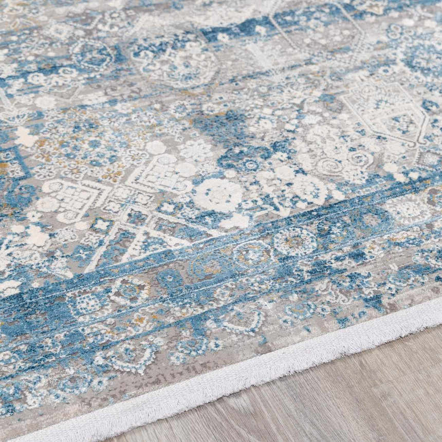 Close-up of the Hartsel Area Rug. Features a traditional pattern in charcoal, dark blue, gray, and mustard tones. Pile
