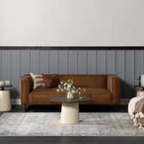Living room scene with a brown leather sofa on the light gray and blue Hartsel Area Rug. Roomscene-Rectangle