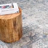 Close-up of the Hartsel Area Rug with a traditional pattern in charcoal, dark blue, gray, and mustard tones. Styleshot