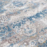 Close-up of the Hartsel Area Rug showing its charcoal, blue, gray, and mustard contemporary pattern. Texture