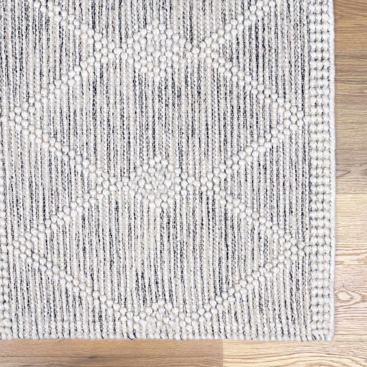 Zoomed-in view of the edge of Whittington Wool Area Rug, focusing on border details and craftsmanship. Transitional,Bohemian Area Rug Backing  