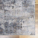 Close-up of the Ironwood Textured Luxe Rug. Abstract pattern in charcoal, gray, light gray, medium brown, and taupe tones. Swatch