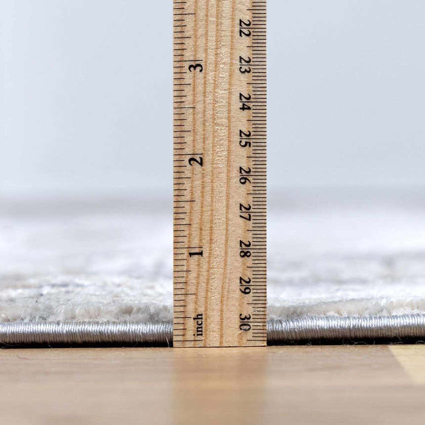 Close-up of Ironwood Textured Luxe Rug pile height, showing its construction and soft texture with a ruler for scale. Pile