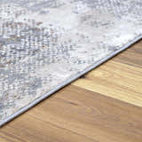 Close-up of the Ironwood Textured Luxe Rug showing charcoal, gray, and brown tones with a subtle, abstract pattern. Pile