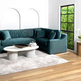 Living room scene with a teal sectional sofa and Ironwood Textured Luxe Rug in gray tones on a wood floor. Roomscene-Rectangle