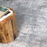 Close-up of the Ironwood Textured Luxe Rug in charcoal, gray, and taupe, with a distressed, contemporary pattern. Styleshot