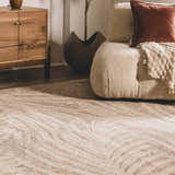 Living room scene with a cream Jens Area Rug, textured sofa, wood cabinet, and neutral decor. Styleshot