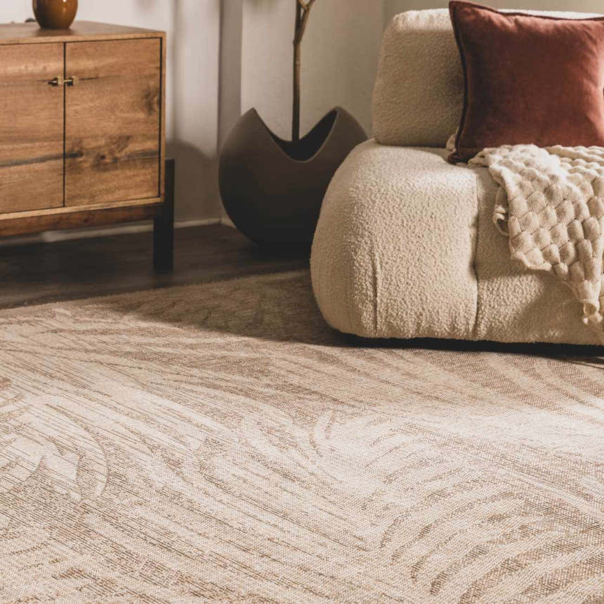 Living room scene with a cream Jens Area Rug, textured sofa, wood cabinet, and neutral decor. Styleshot