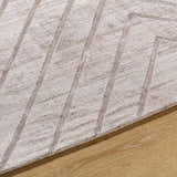 Close-up of the Tavran Taupe rug showing subtle linear texture and soft beige tones on a wood floor. Viscose hand-loomed rug. Texture