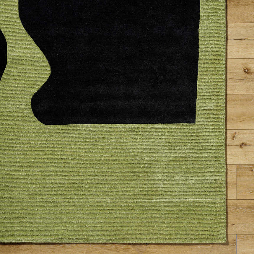 Close up of the Arvok Olive Green rug showing the charcoal block pattern and hand-tufted wool texture. Corner