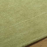 Close-up of the textured Arvok Olive Green wool rug, showing the hand-tufted construction and subtle block pattern. Texture