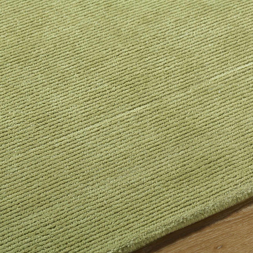 Close-up of the textured Arvok Olive Green wool rug, showing the hand-tufted construction and subtle block pattern. Texture