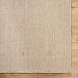 Close-up of the hand woven texture of the Cilaa Modern Wool Area Rug in a neutral beige color on hardwood floor. Corner