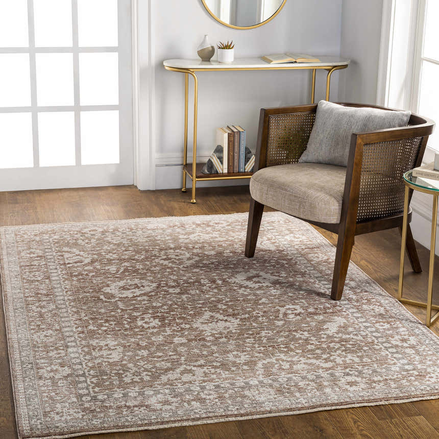 Living room scene with a brown and ivory Kaongkod Area Rug, cane chair, and gold accent tables. Roomscene-Rectangle