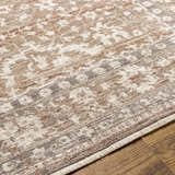 Close-up of the Kaongkod Area Rug. Farmhouse style rug in dusty pink, ivory, and brown with a traditional pattern. Texture