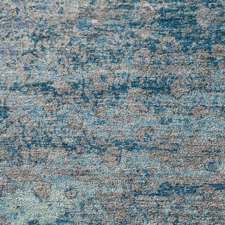 Close-up of the Dalyn Luxury Kochi KC13 Gray Area Rug. Features a textured pattern in denim, silver gray, and teal.