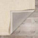 Close up of the hand-tufted Kayoko Ivory Area Rug showing the wool texture, grid pattern, and rug backing. Fold