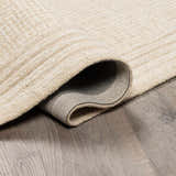 Close-up of textured Kayoko Ivory Area Rug showing the hand-tufted wool and backing. Fold