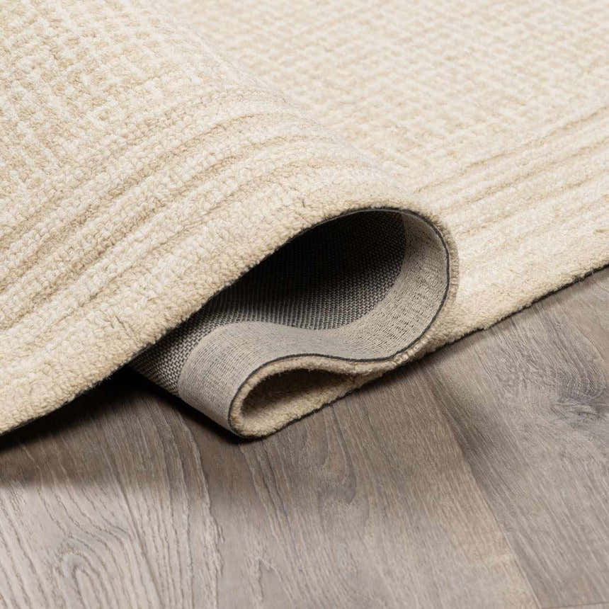 Close-up of textured Kayoko Ivory Area Rug showing the hand-tufted wool and backing. Fold
