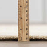 Close-up of the thick pile height of the hand-tufted Kayoko Ivory Area Rug, showing its texture. Pile