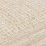 Close-up of the hand-tufted Kayoko Ivory Area Rug. Cream and off-white wool with subtle geometric pattern. Soft texture. Texture