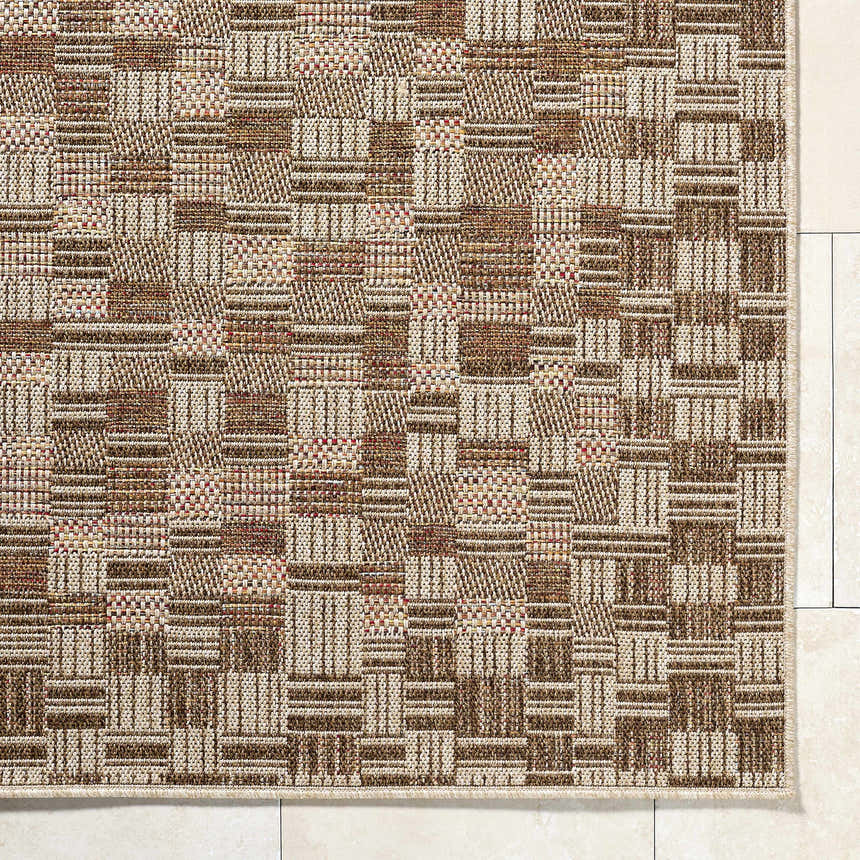 Close-up of the Arshad Burnt Sienna Area Rug. Woven texture in burnt sienna, ivory, sandstone, and terracotta hues. Corner