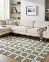 Living room scene with a cream sectional sofa and the Kalkin Olive Area Rug featuring a green and white diamond pattern. Roomscene-Rectangle