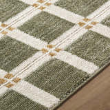 Close up of the Kalkin Olive Area Rug. Features an olive, white, and tan plaid pattern. Machine woven texture. Texture