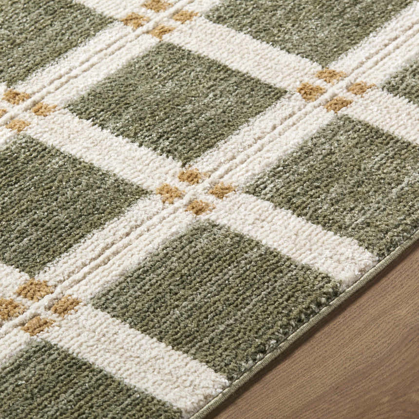 Close up of the Kalkin Olive Area Rug. Features an olive, white, and tan plaid pattern. Machine woven texture. Texture