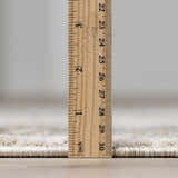 Close-up of Kress Thick Luxe Abstract Rug pile height, showing plush texture and edge binding with a ruler. Pile