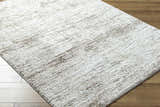 Close up of the textured Kohaku Light Gray Area Rug on a wood floor. Corner