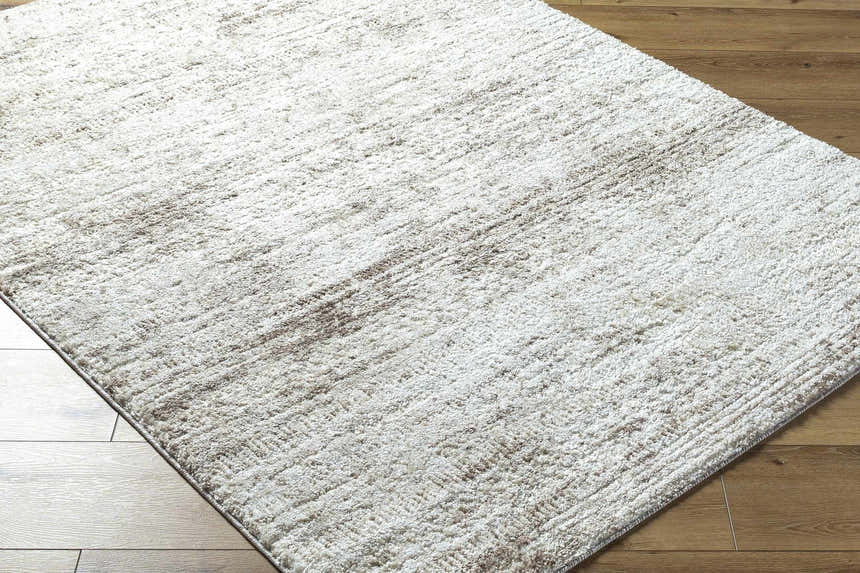 Close up of the textured Kohaku Light Gray Area Rug on a wood floor. Corner