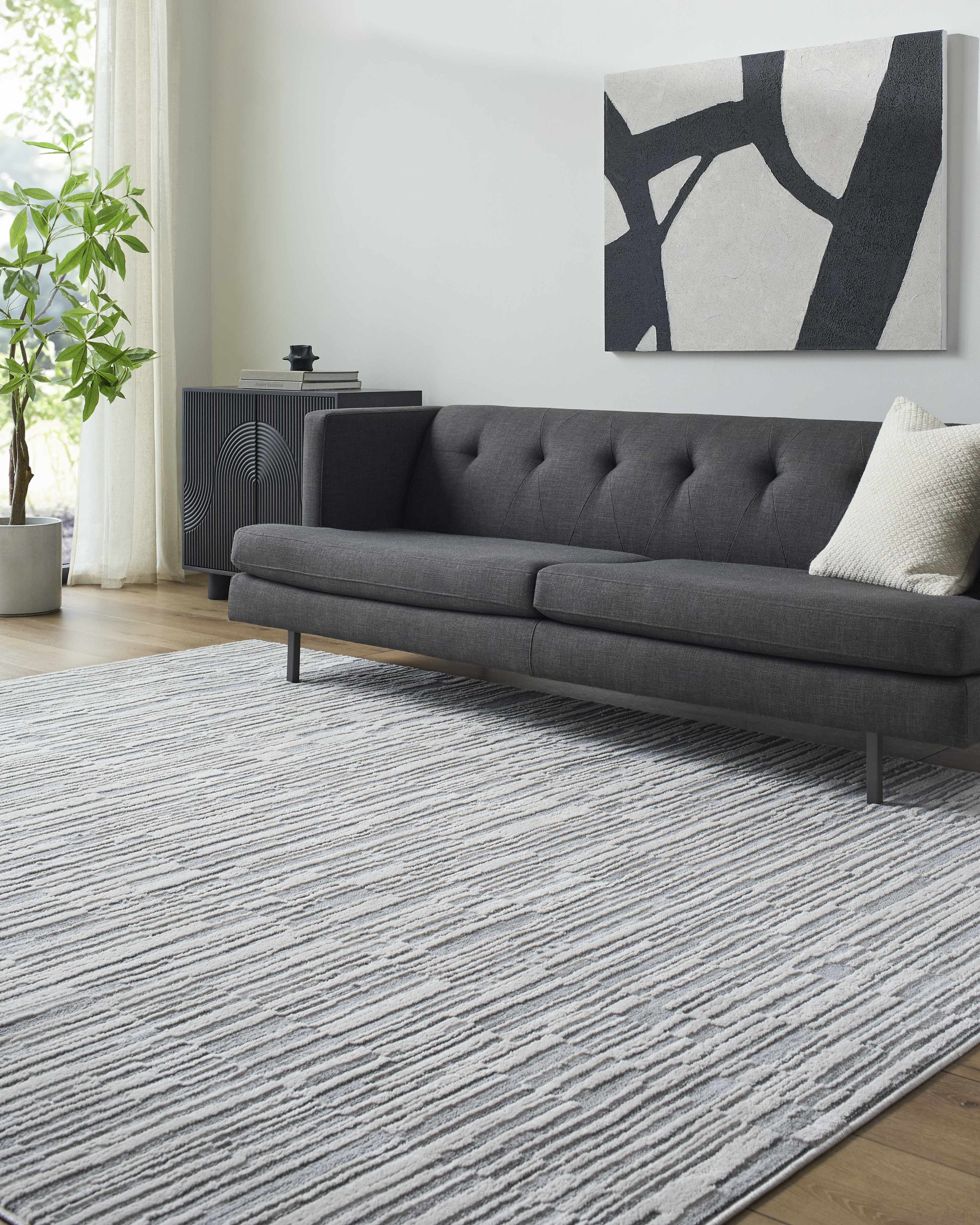Alexey Gray Broken-Striped Area Rug placed in a styled room setting, harmonizing with surrounding room decor. Contemporary Area Rug Backing  