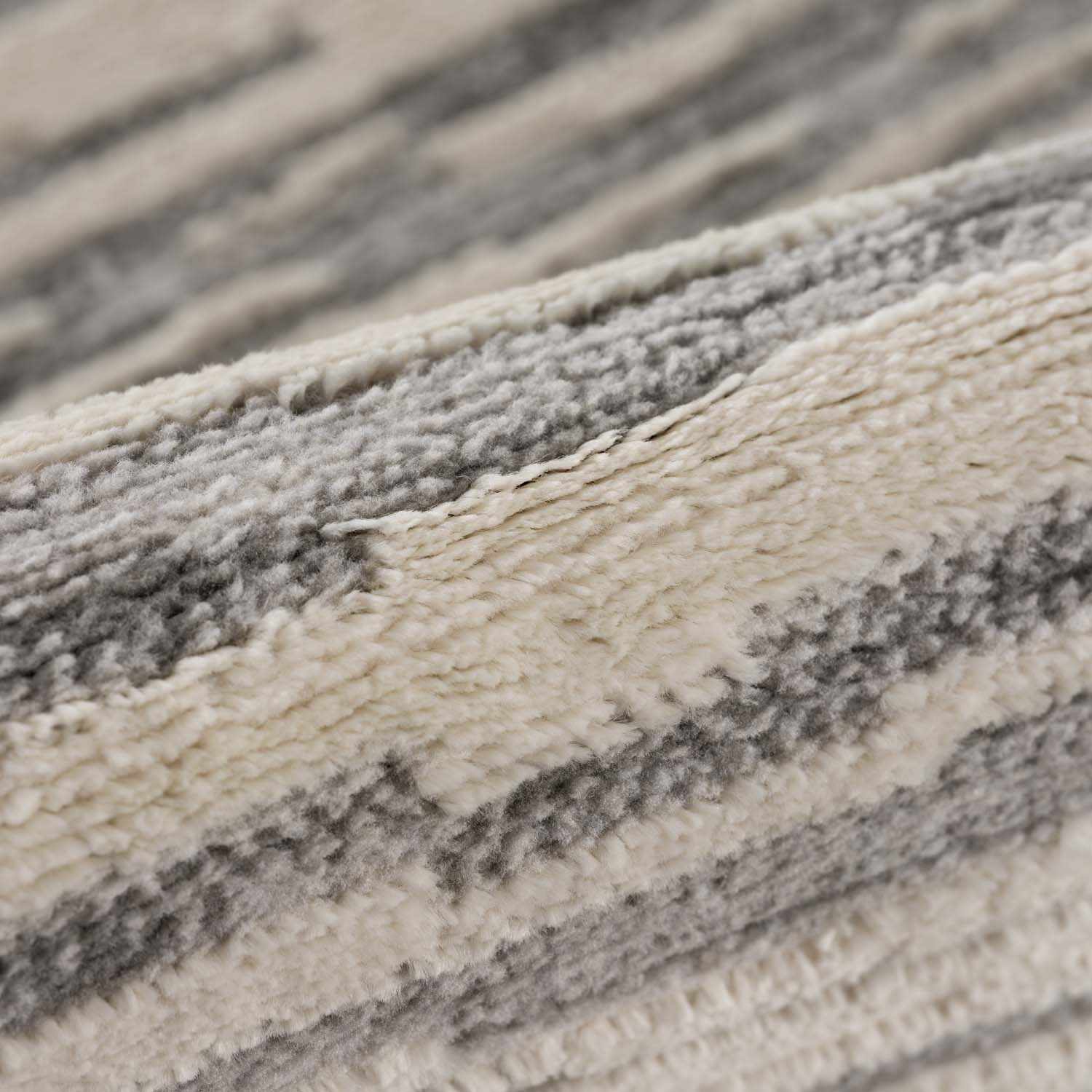 Folded section of Alexey Gray Broken-Striped Area Rug, displaying material thickness and weave. Contemporary Area Rug Backing  