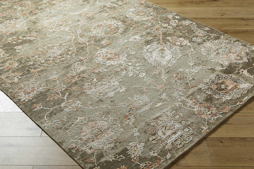 Close-up of the hand-knotted Limay Premium Wool Rug. Features a traditional floral pattern in olive, beige, and coral tones. Corner